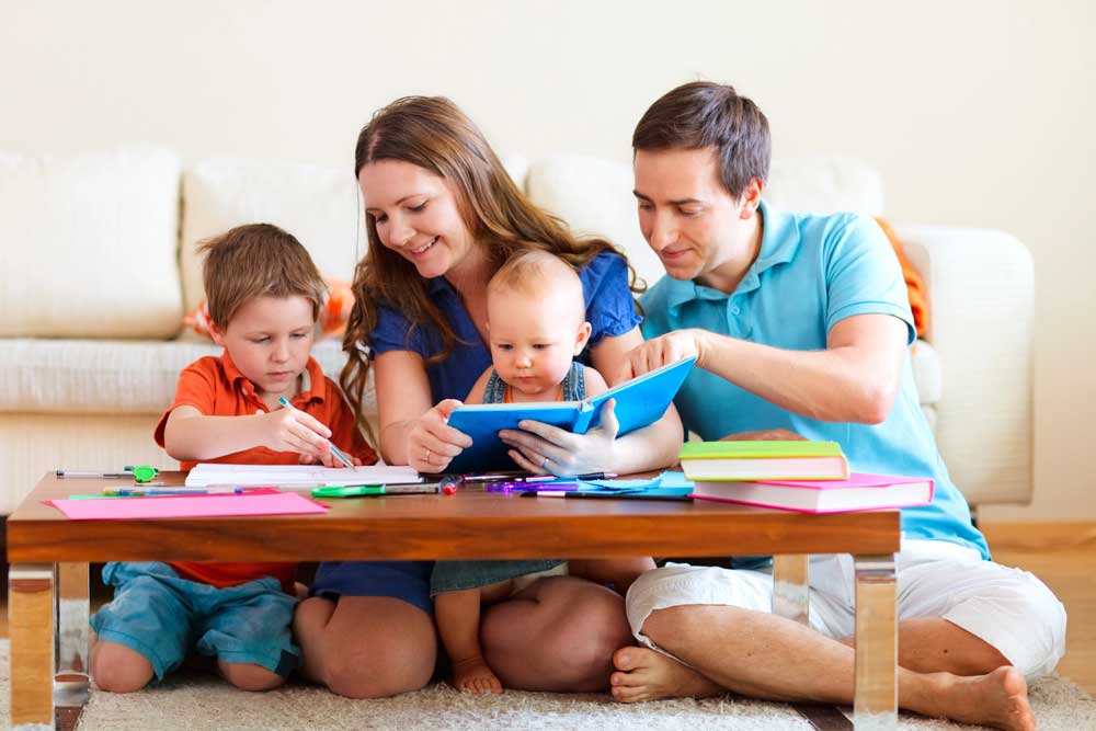 familie fericita cu copii care citesc impreuna o carte